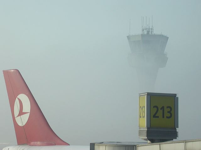 Aircraft wing slicing through fog over Istanbul