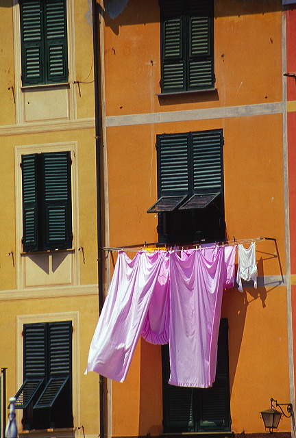 Laundry hanging between pastel facades in Portofino