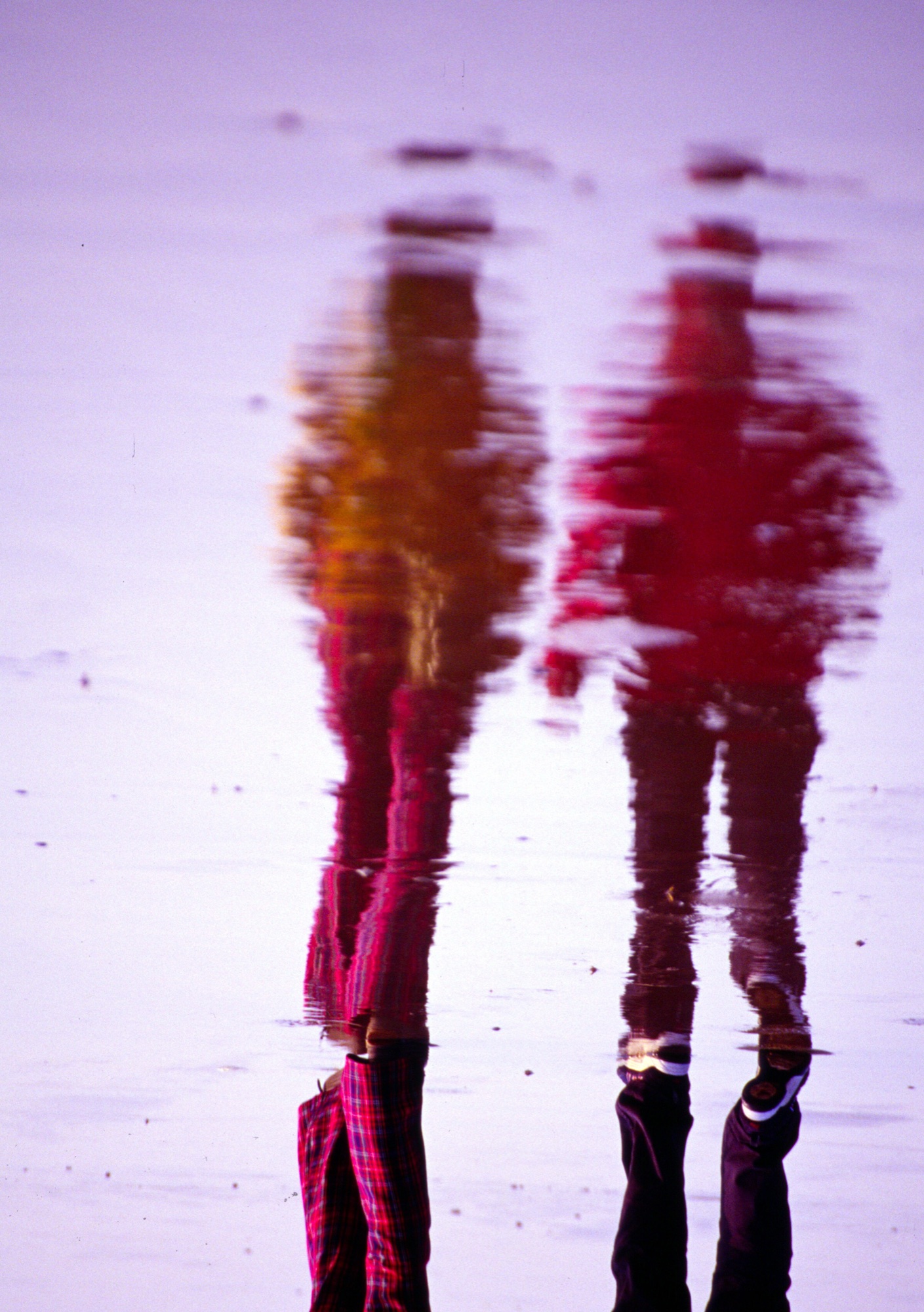 Quiet coastal mirror reflection and passing figure on the French Atlantic shore