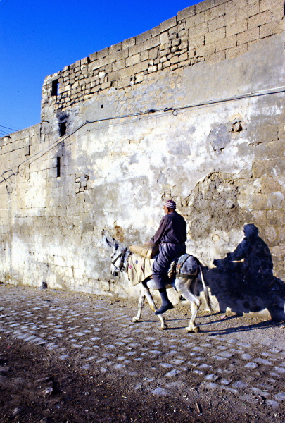 Man riding a bicycle through historic stone streets in Urfa